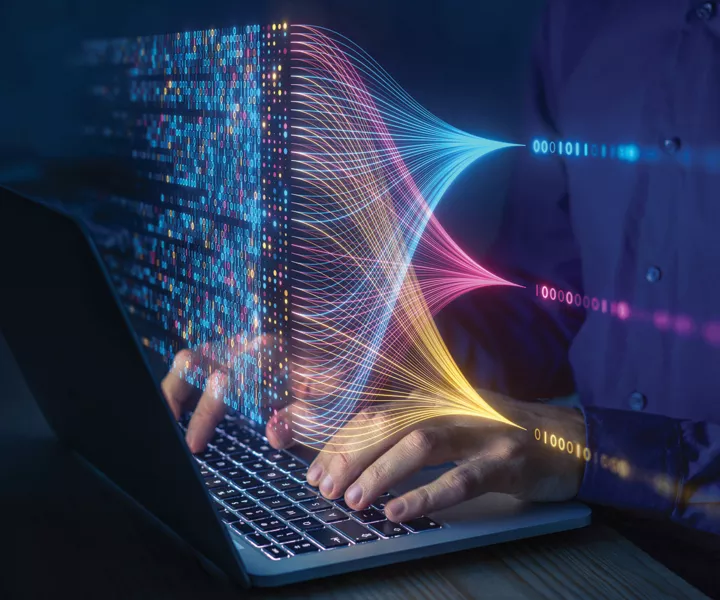 Hands writing on Laptop an colourful code above